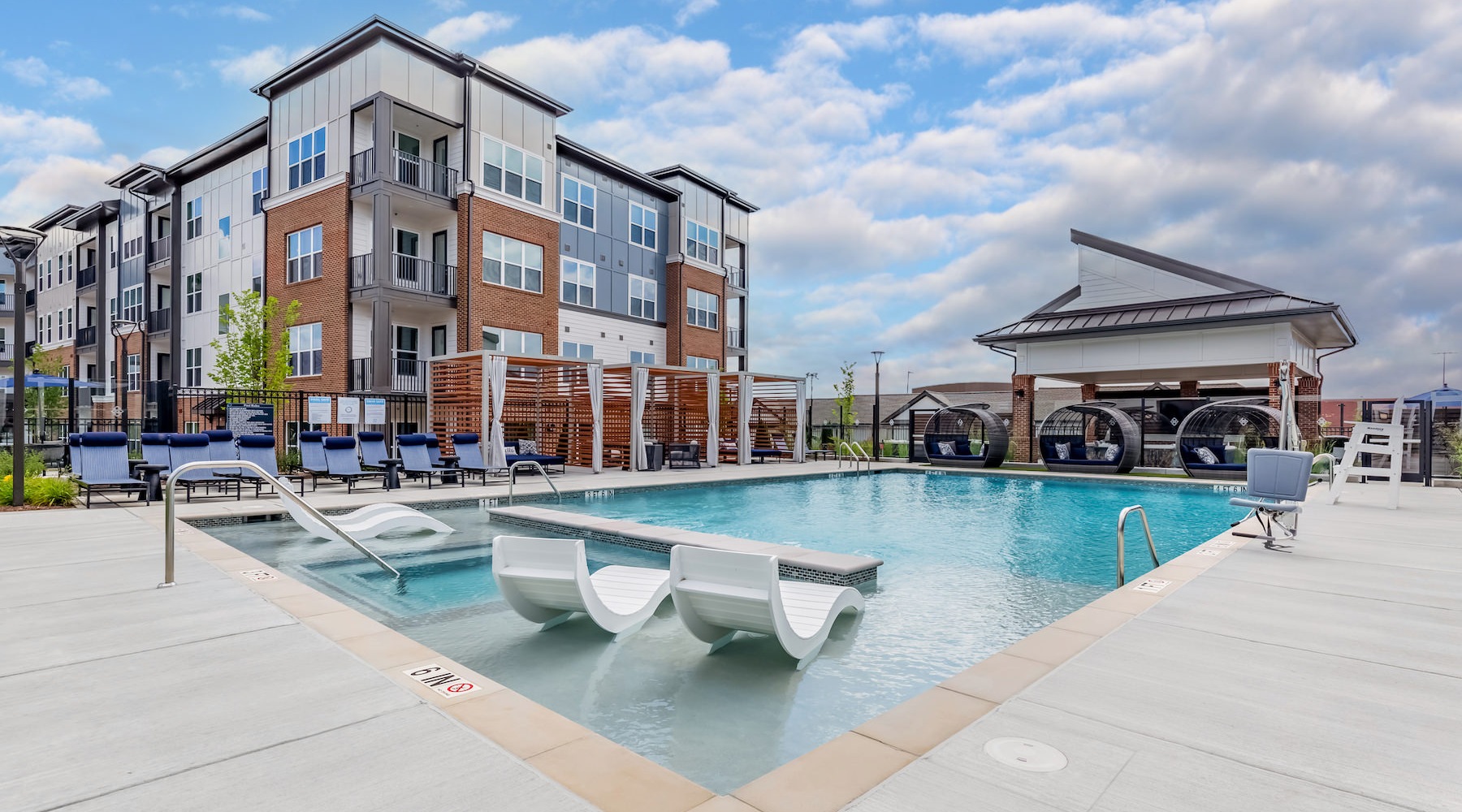 outdoor swimming pool with a tanning shelf at Bainbridge Market Commons in Frederick, MD
