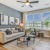 Spacious and well lit living room with wood flooring, large windows and open access to the kitchen at Bainbridge Market Commons in Frederick, MD